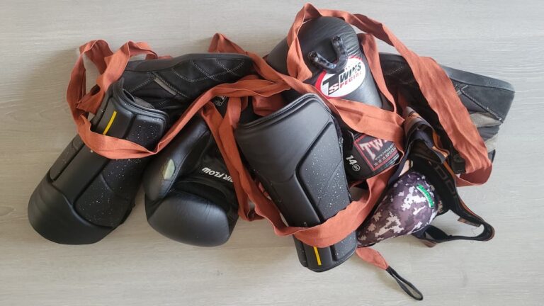 Un ensemble de matériel de boxe française posé au sol, prêt pour un entraînement de savate.