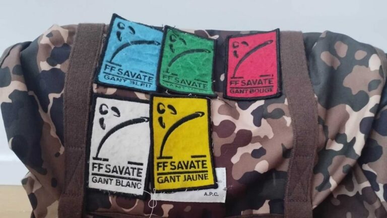 Sac de sport arborant les 5 écussons des grades techniques de Savate Boxe Française, cousus dans l'ordre du Gant Bleu au Gant Jaune